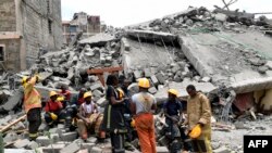 Rescuers take a break at the scene of a collapsed building, blamed on poor construction materials in Kirigiti, Kiambu county, on September 26, 2022.