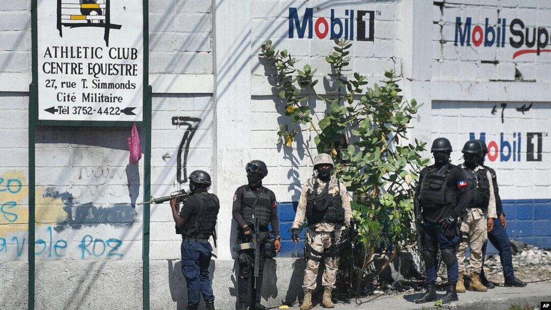 FILE - Police stand at a corner after exchanging gunfire with a gang at one of the entrances to the Cite Soleil slum of Port-au-Prince, Haiti, Nov. 9, 2021. Two Haitian journalists were killed while reporting in the Cite Soleil district on Sept. 11, 2022.