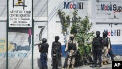 FILE - Police stand at a corner after exchanging gunfire with a gang at one of the entrances to the Cite Soleil slum of Port-au-Prince, Haiti, Nov. 9, 2021. Two Haitian journalists were killed while reporting in the Cite Soleil district on Sept. 11, 2022.
