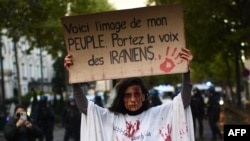 یک معترض در جریان تظاهرات حمایت از معترضان ایرانی در پاریس در ۲۵ سپتامبر ۲۰۲۲ - نوشته روی پلاکارد: «این تصویر مردم من است. صدای ایرانیان باشید» 