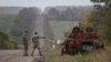 Украинские военнослужащие исследуют сожженный российский бронетранспортер недалеко от города Изюм, недавно освобожденного украинскими вооруженными силами, Харьковская область, Украина, 24 сентября 2022 года
