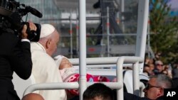 El papa Francisco acaricia a un bebé antes de una misa en Expo Grounds en Nur-Sultan, Kazajistán, el miércoles 14 de septiembre de 2022. El papa Francisco está en el segundo día de su viaje de tres días a Kazajistán. (Foto AP/Stanislav Filippov)