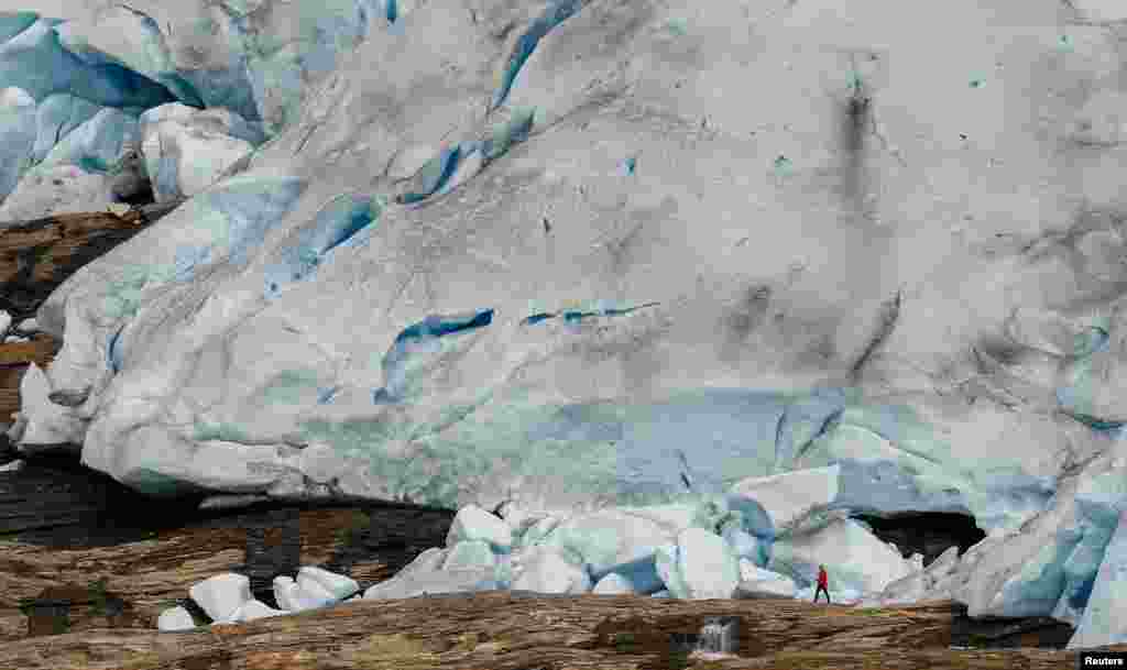 A hiker stands in front of Austerdalsisen, the south side of the inland part of Svartisen glacier, one of Norway&#39;s largest glaciers near Mo i Rana, Sept. 19, 2022.