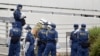 Petugas polisi dan petugas pemadam kebakaran menyelidiki lokasi di mana seorang pria melakukan protes terhadap rencana pemakaman kenegaraan mantan Perdana Menteri Jepang Shinzo Abe dengan membakar dirinya sendiri, di Tokyo, Jepang 21 September 2022. (Foto: Kyodo via Reuters)