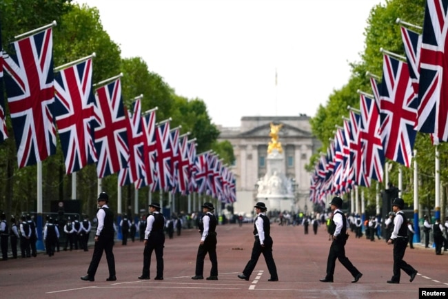 Police officers are seen in The Mall, central London, ahead of the ceremonial procession of the coffin of Queen Elizabeth from Buckingham Palace to Westminster Hall, Sept. 14, 2022.