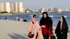 FILE - Women walk on the shore of the Persian Gulf Martyrs' Lake in Tehran, July 6, 2019. Some women in Iran have been taking off mandatory headscarves, or hijabs, in public, risking arrest.