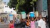 Mujeres cargan depósitos llenos de agua en medio de una escasez en Puerto Príncipe, Haití, el 17 de septiembre de 2022.