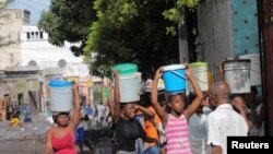 Mujeres cargan depósitos llenos de agua en medio de una escasez en Puerto Príncipe, Haití, el 17 de septiembre de 2022.