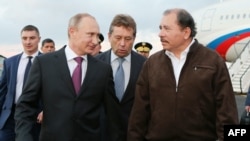 FILE - Russian President Vladimir Putin, 2nd left, walks with Nicaraguan President Daniel Ortega, right, at the Augusto C. Sandino Airport in Managua, July 11, 2014, in this handout photo distributed by the Presidencia de Nicaragua.