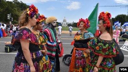 Integrantes de una compañía de danza folclórica mexicana conversan antes de salir de la Explanada Nacional en Washington DC. Al fondo el emblemático Capitolio en la capital estadounidense. (Foto VOA / Tomás Guevara)