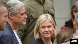 Swedish Prime Minister Magdalena Andersson and her husband, Richard Friberg, arrive to cast their votes at a polling center in Nacka, near Stockholm on September 11, 2022, during Sweden's general elections. 