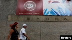 ARCHIVO - La gente camina fuera del Banco Central de Venezuela en Caracas, Venezuela, 31 de enero de 2018. REUTERS/Marco Bello