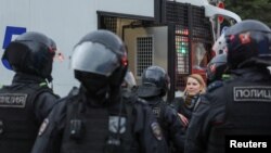 FILE - Russian law enforcement officers surround a person during a rally, after opposition activists called for street protests against the mobilization of reservists ordered by President Vladimir Putin, in Moscow, Sept. 24, 2022.