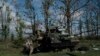 Ukrainian national guard servicemen remove the body of a Ukrainian soldier from an armored vehicle in an area near the border with Russia, in Kharkiv region, Ukraine, Sept. 19, 2022.