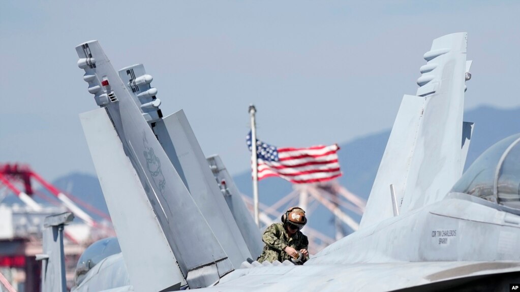 2022年9月23日，美国士兵在抵达韩国釜山港口的核动力航空母舰罗纳德·里根号的甲板上检查 F/A-18 超级大黄蜂战斗机。(photo:VOA)