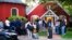 FILE - Immigrants gather with their belongings outside St. Andrews Episcopal Church, Sept. 14, 2022, in Edgartown, Mass., on Martha's Vineyard. 