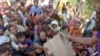 FILE - Displaced families get relief aid distributed by soldiers of Pakistan rangers in Balochistan province, Sept. 17, 2022. 