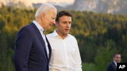 FILE - French President Emmanuel Macron, center, speaks with U.S. President Joe Biden after a group photo at the G7 summit at Castle Elmau in Kruen, near Garmisch-Partenkirchen, Germany, on June 26, 2022. 