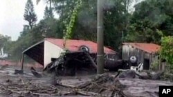 ARCHIVO - Toma de video de altas corrientes en la calle con un auto volcado causado por fuertes lluvias, San Salvador, El Salvador, en octubre de 2005.