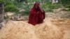 Fatuma Abdi Aliyow se lamenta junto a las tumbas de sus dos hijos muertos por enfermedades relacionadas con la desnutrición, en un campamento para desplazados, el 3 de septiembre de 2022, en las afueras de Mogadiscio, Somalia. 