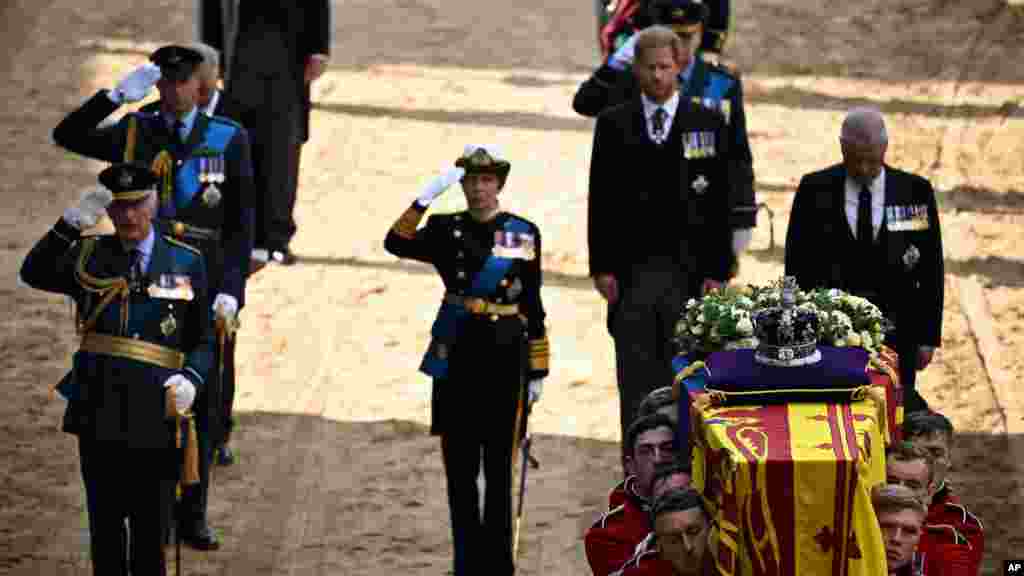 King Charles III, Prince William, and Princess Anne salute alongside Prince Andrew and Prince Harry, as the coffin of Queen Elizabeth II, is carried into the Palace of Westminster, Sept. 14, 2022.