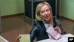 Brothers of Italy's leader Giorgia Meloni votes at a polling station in Rome, on Sept. 25, 2022. Italians are voting in a national election that might yield the nation's first government led by the far right since the end of World War II. 