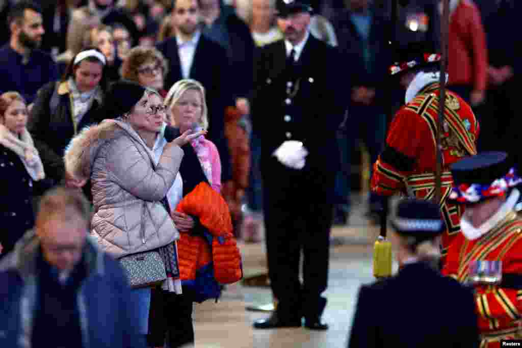 Members of the public pay their respects to Queen Elizabeth II&#39;s flag-draped coffin lying in state on the catafalque at Westminster Hall, Sept. 18, 2022 in London.