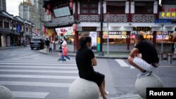 2022年9月9日上海新冠爆發後，人們在街道石頭路障上休息