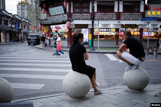 People rest on stone barricades on a street, following the coronavirus disease (COVID-19) outbreak, in Shanghai, China, September 9, 2022. (REUTERS/Aly Song)