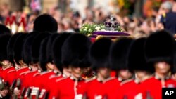 The Imperial State Crown rests on the coffin of Queen Elizabeth II during the procession from Buckingham Palace to Westminster Hall in London, Sept. 14, 2022. 
