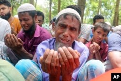 Pengungsi Rohingya menangis saat berdoa dalam pertemuan untuk memperingati lima tahun eksodus mereka dari Myanmar ke Bangladesh, di kamp pengungsi Rohingya Kutupalong di Ukhiya di distrik Cox's Bazar, Bangladesh, 25 Agustus 2022. (Foto: AP)