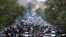Para demonstran meneriakkan slogan-slogan selama aksi protes atas kematian seorang perempuan yang ditahan oleh polisi moral Iran, di pusat ibu kota Teheran, 21 September 2022. 