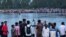 In this picture taken on Sept. 25, 2022, people gather along the banks of the Karatoya River after a boat capsized near the town of Boda in Bangladesh. A day later, rescue workers recovered seven more bodies.