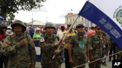 Exguerrilleros cantan el himno nacional después de asistir a una marcha antigubernamental el Día de la Independencia en San Salvador, El Salvador, el jueves 15 de septiembre de 2022. (AP Foto/Salvador Melendez)