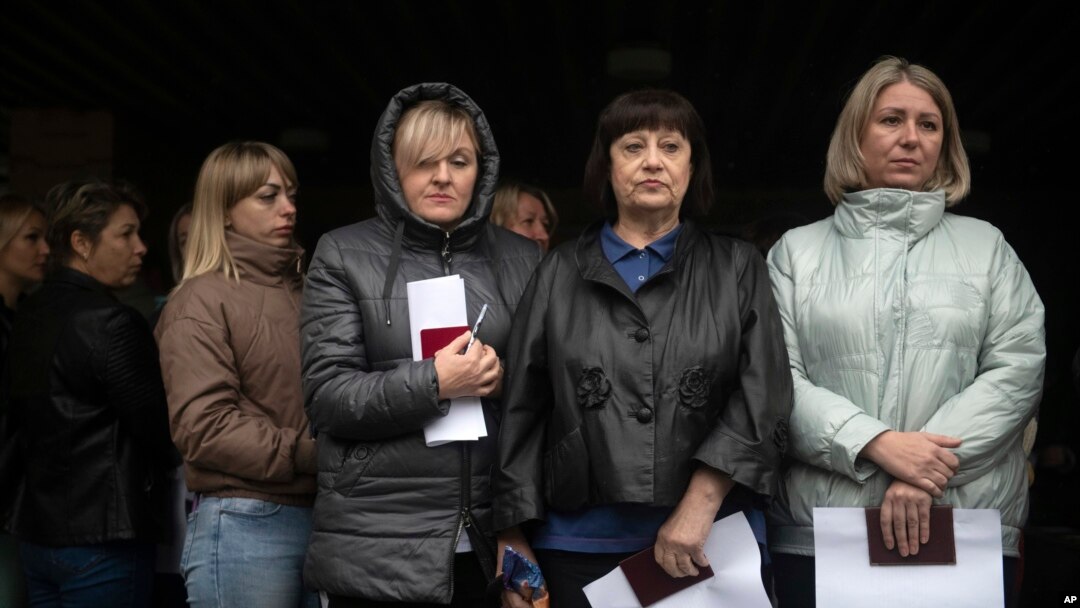 Women wait to vote in a Russia-staged referendum in front of a polling station in Luhansk, eastern Ukraine, Sept. 23, 2022. The voting, viewed as a sham by Ukraine and Western countries, began Friday in four Moscow-held regions of Ukraine on whether they should join Russia.