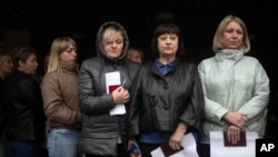 Women wait to vote in a Russia-staged referendum in front of a polling station in Luhansk, eastern Ukraine, Sept. 23, 2022. The voting, viewed as a sham by Ukraine and Western countries, began Friday in four Moscow-held regions of Ukraine on whether they should join Russia.