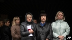 Mujeres esperan para votar en un referéndum organizado por Rusia frente a un centro de votación móvil en Luhansk, este de Ucrania, el 23 de septiembre de 2022.