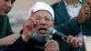 FILE - Egyptian cleric Sheik Youssef al-Qardawi speaks to the crowd as he leads Friday prayers in Tahrir Square in Cairo, Egypt, Feb. 18, 2011. Al-Qardawi, a cleric who was seen as the spiritual leader of the pan-Arab Muslim Brotherhood, has died at the age of 96.