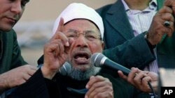 FILE - Egyptian cleric Sheik Youssef al-Qardawi speaks to the crowd as he leads Friday prayers in Tahrir Square in Cairo, Egypt, Feb. 18, 2011. Al-Qardawi, a cleric who was seen as the spiritual leader of the pan-Arab Muslim Brotherhood, has died at the age of 96.