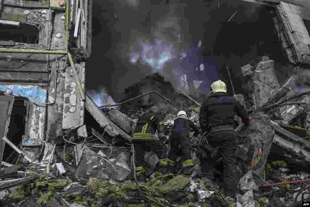 Firefighters put out a fire after a flat was hit by a missile strike in Bakhmut, Donetsk region, Ukraine.