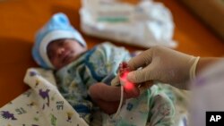 FILE - Veronika, a baby born prematurely at 29 weeks, is checked at the Pokrovsk Perinatal Hospital, the only one under government control equipped to take care of premature babies, in Pokrovsk, Donetsk region, eastern Ukraine, Aug. 15, 2022.