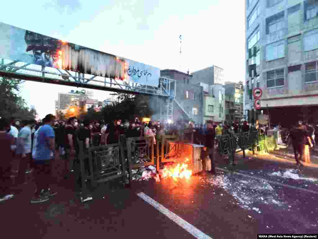 People light a fire during a protest over the death of Mahsa Amini, a woman who died after being arrested by the Islamic republic&#39;s &quot;morality police&quot;, in Tehran, Iran, Sept. 21, 2022.