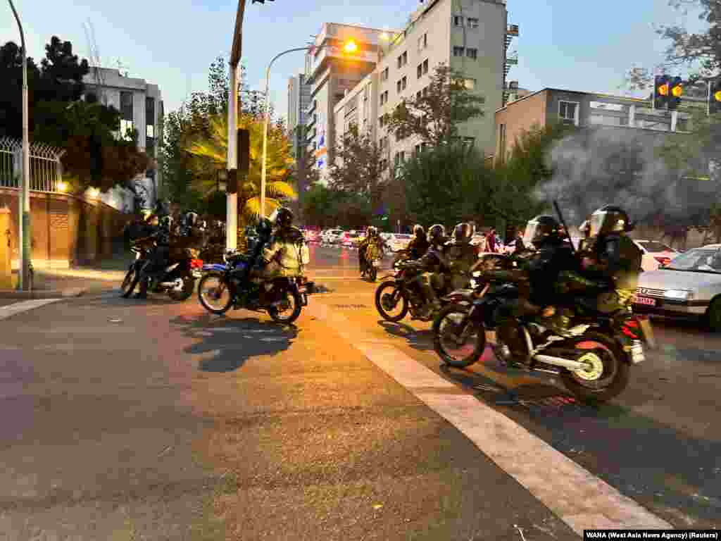 Police arrive to disperse demonstrators during a protest over the death of Mahsa Amini, a woman who died after being arrested by the Islamic republic's "morality police", in Tehran, Iran, Sept. 19, 2022.