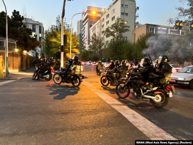 FILE - Police arrive to disperse demonstrators during a protest over the death of Mahsa Amini, a woman who died after being arrested by the Islamic republic's "morality police," in Tehran, Iran, Sept. 19, 2022.
