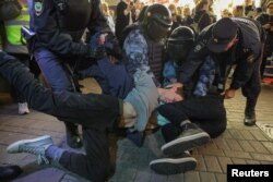 Russian law enforcement officers detain men during an unsanctioned rally, after opposition activists called for street protests against the mobilization of reservists ordered by President Vladimir Putin, in Moscow, Russia Sept. 21, 2022.