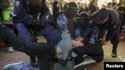Russian law enforcement officers detain men during an unsanctioned rally, after opposition activists called for street protests against the mobilization of reservists ordered by President Vladimir Putin, in Moscow, Russia Sept. 21, 2022.