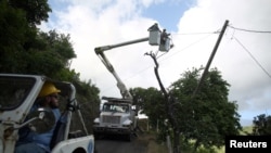 FILE - Workers of Puerto Rico's Electric Power Authority (PREPA) repair part of the electrical grid as the island's fragile power system is still reeling from the devastation wrought by Hurricane Maria, in Utuado, Puerto Rico May 17, 2018. 