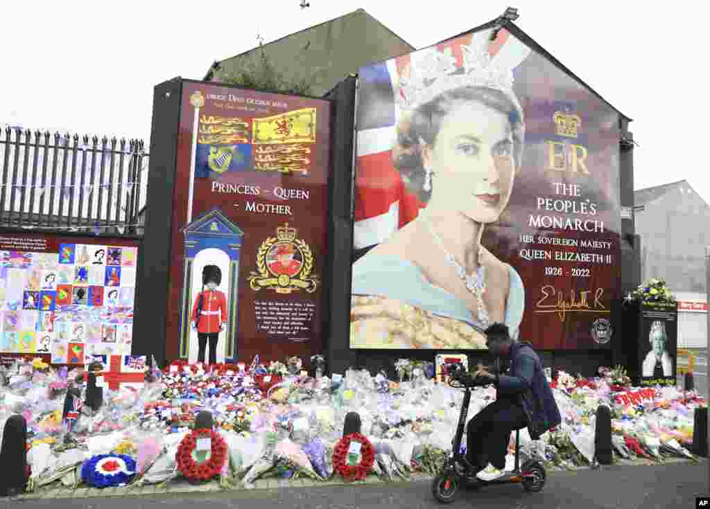A man looks at floral tributes for Queen Elizabeth II on the Shankill Road in West Belfast, Northern Ireland.