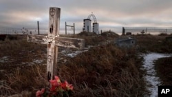 FILE - This Feb. 7, 2012 photo shows a cross on a grave at the Wounded Knee National Historic landmark in South Dakota.