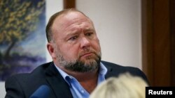 FILE - Alex Jones attempts to answer questions about his emails asked by Mark Bankston, lawyer for Neil Heslin and Scarlett Lewis, during trial at the Travis County Courthouse, Austin, Texas, U.S., Aug. 3, 2022. 